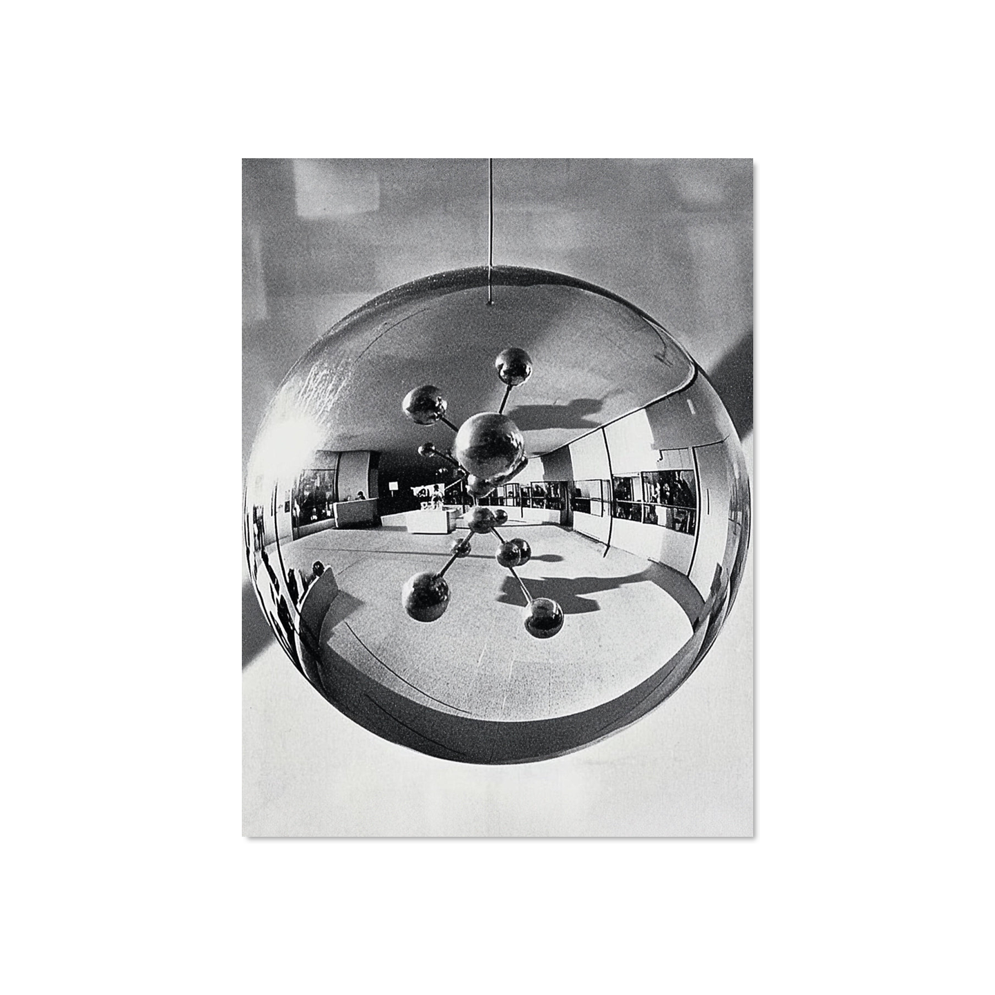 Reflective surface showing a building interior with a modern chandelier.